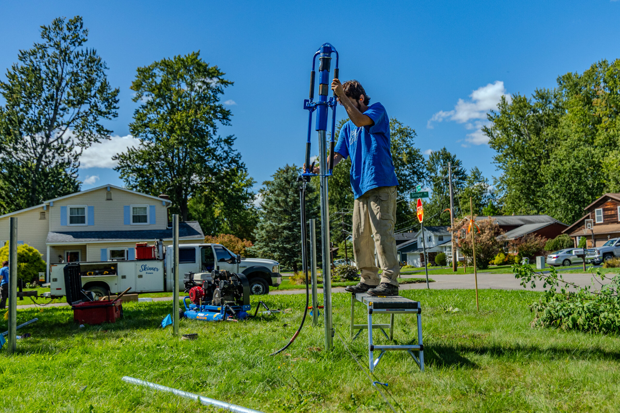 Fence Installation in Liverpool - NY underway as a crew sets posts along a backyard property line