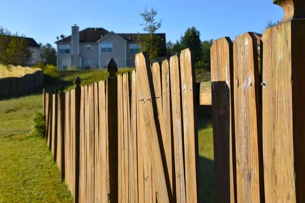 Specialist completing gate installation at a Liverpool - NY fence line while adjusting latch hardware