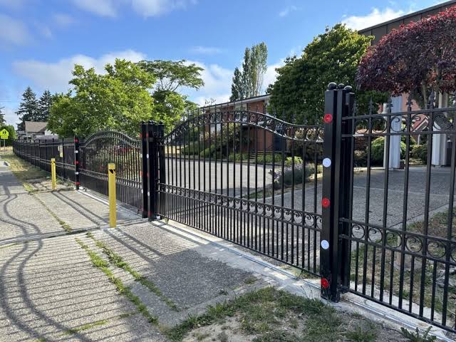 Technician performing fence repair on a damaged gate in Liverpool - NY while checking hinge alignment